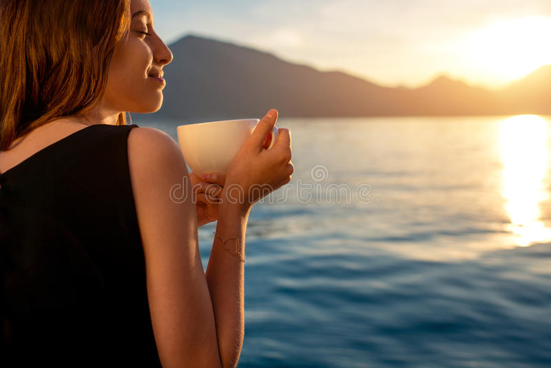 young-woman-drinking-coffee-pier-sunrise-enjoying-mountains-background-53303362.jpg